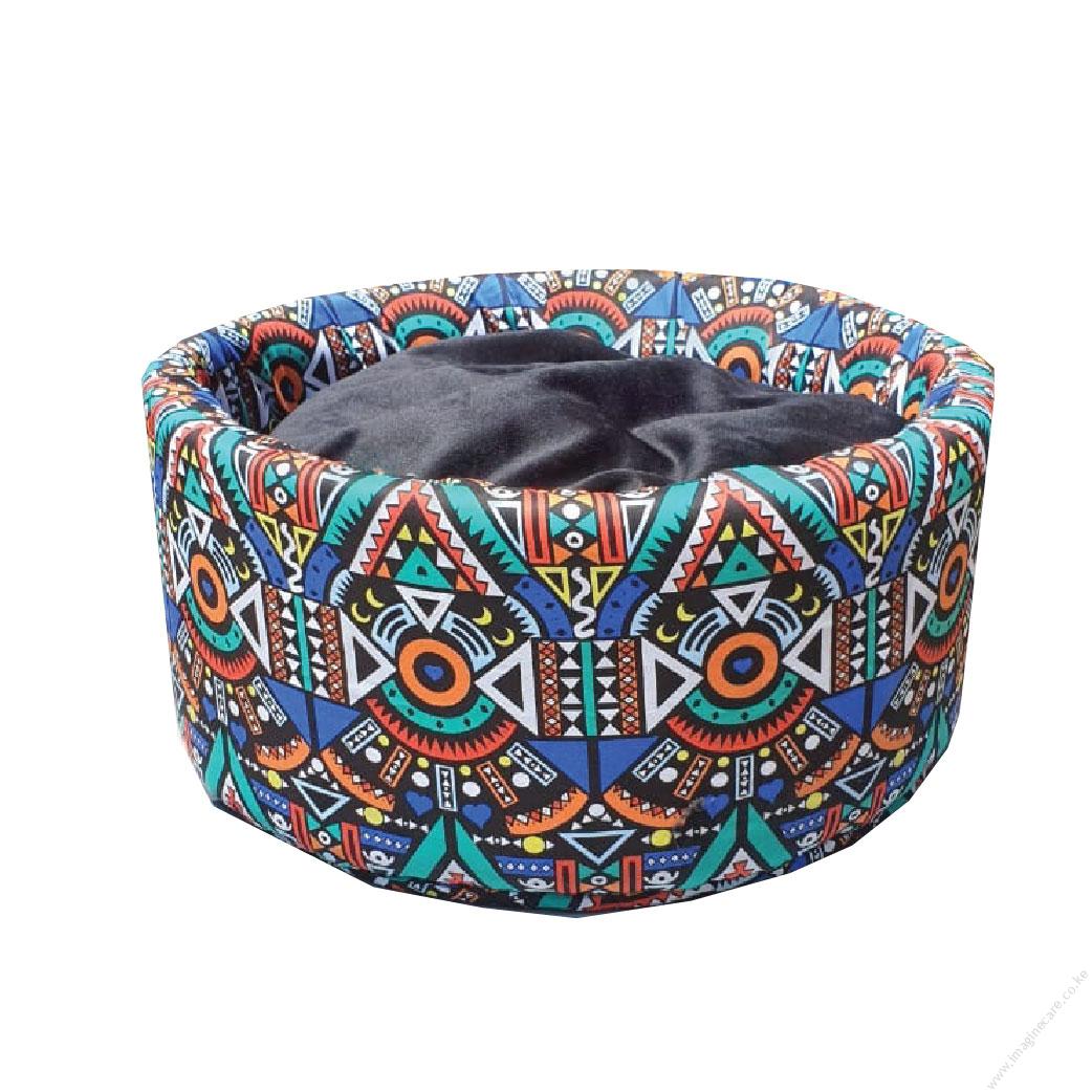 Circular, fluffy cat bed with an African print.